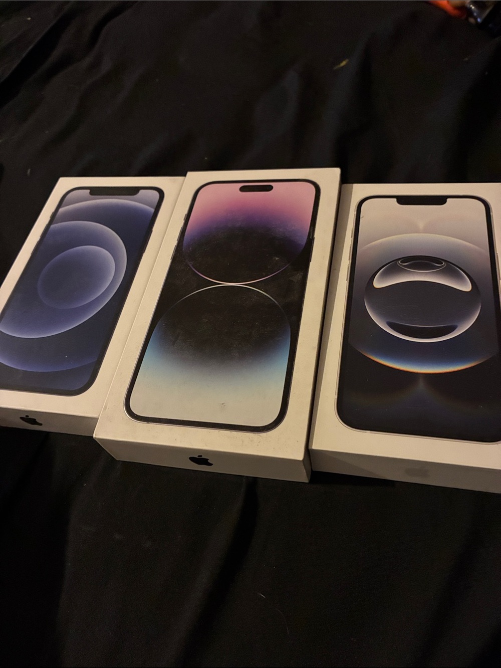 Apple iPhone Trio in Blue, Purple, and Black Display Artwork